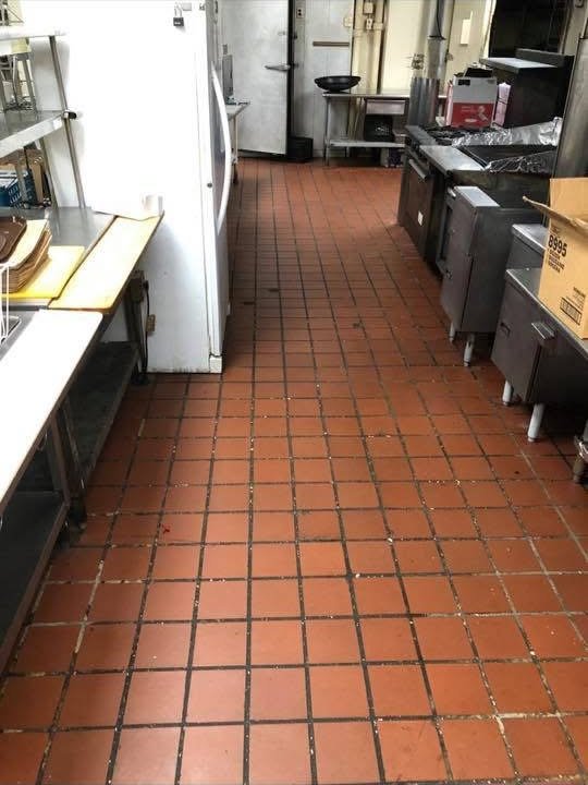 Commercial kitchen tile floor before deep cleaning, with grime and debris buildup